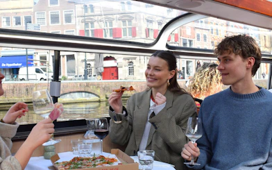 Guests enjoying pizza and wine on a Haarlem canal cruise.