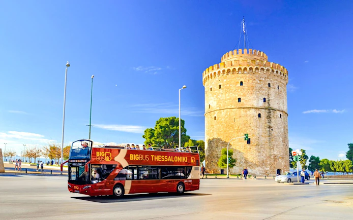 Big Bus tour passing the White Tower in Thessaloniki, Greece.