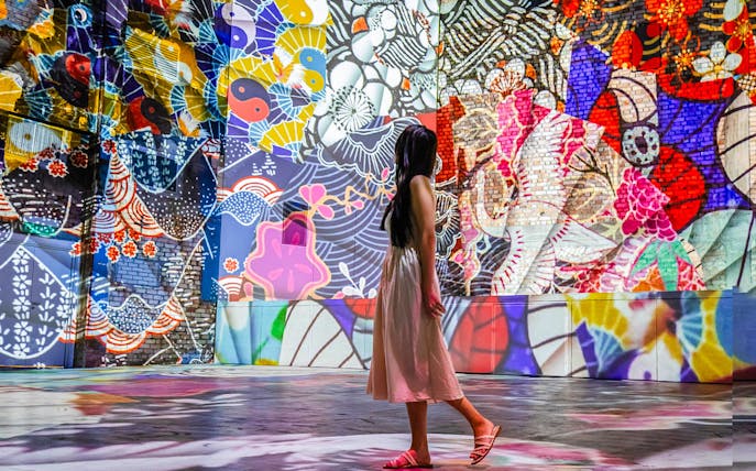 Visitor exploring vibrant murals at Other World Immersive Art Gallery, REXKL.