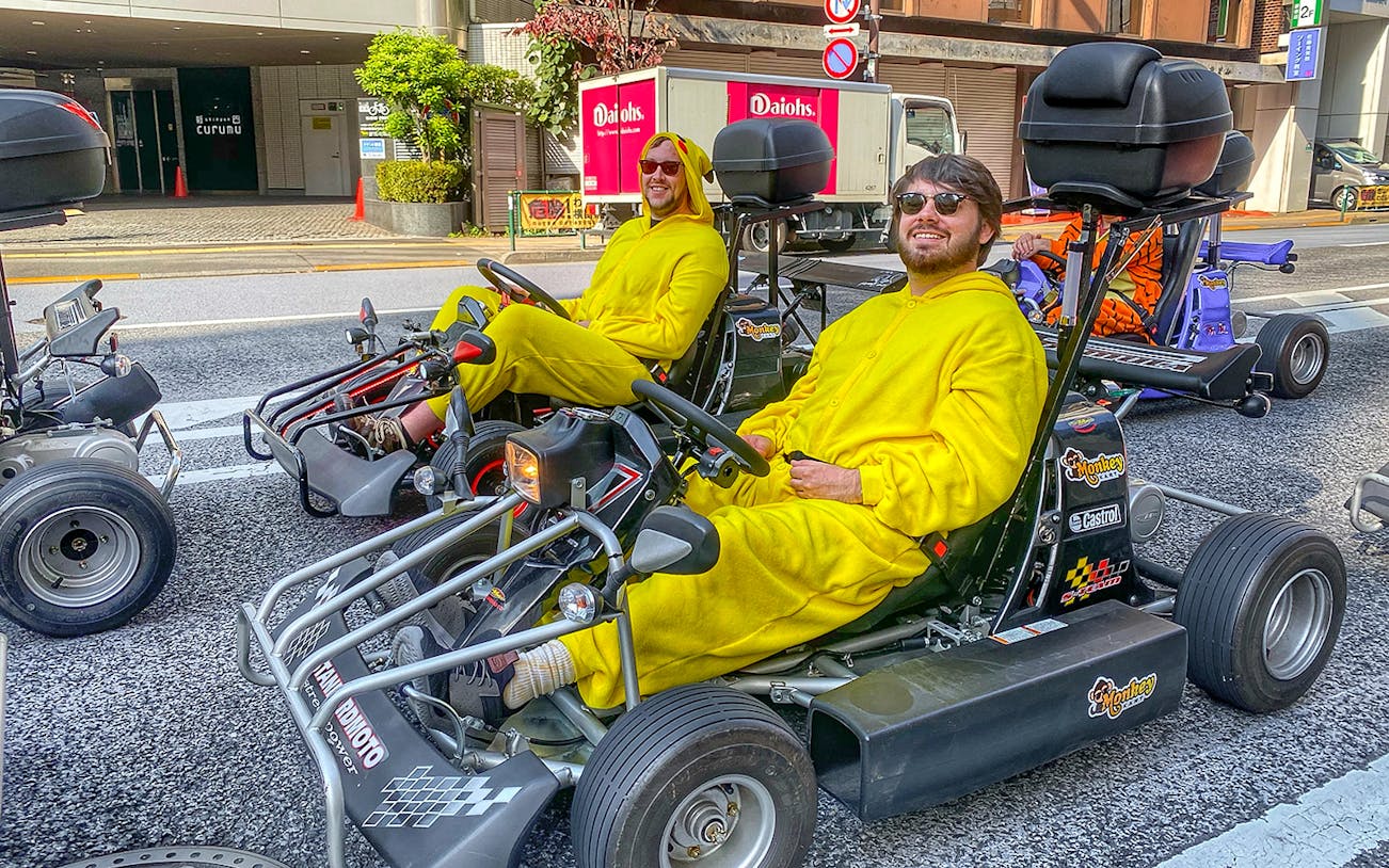 Go-kart riders in yellow costumes on Tokyo street during Skytree tour.