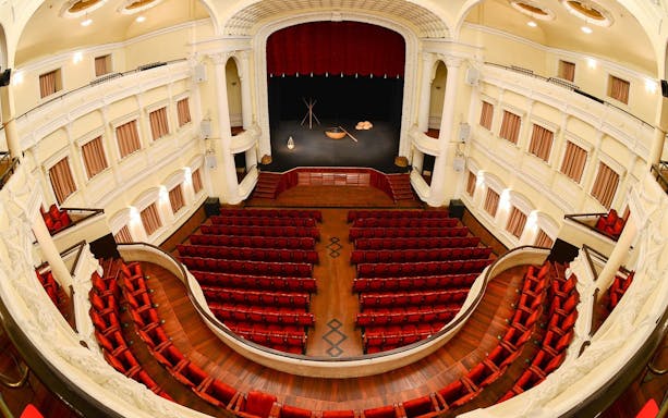 Stage view at A O Show circus in Vietnam with red seats and ornate balcony.