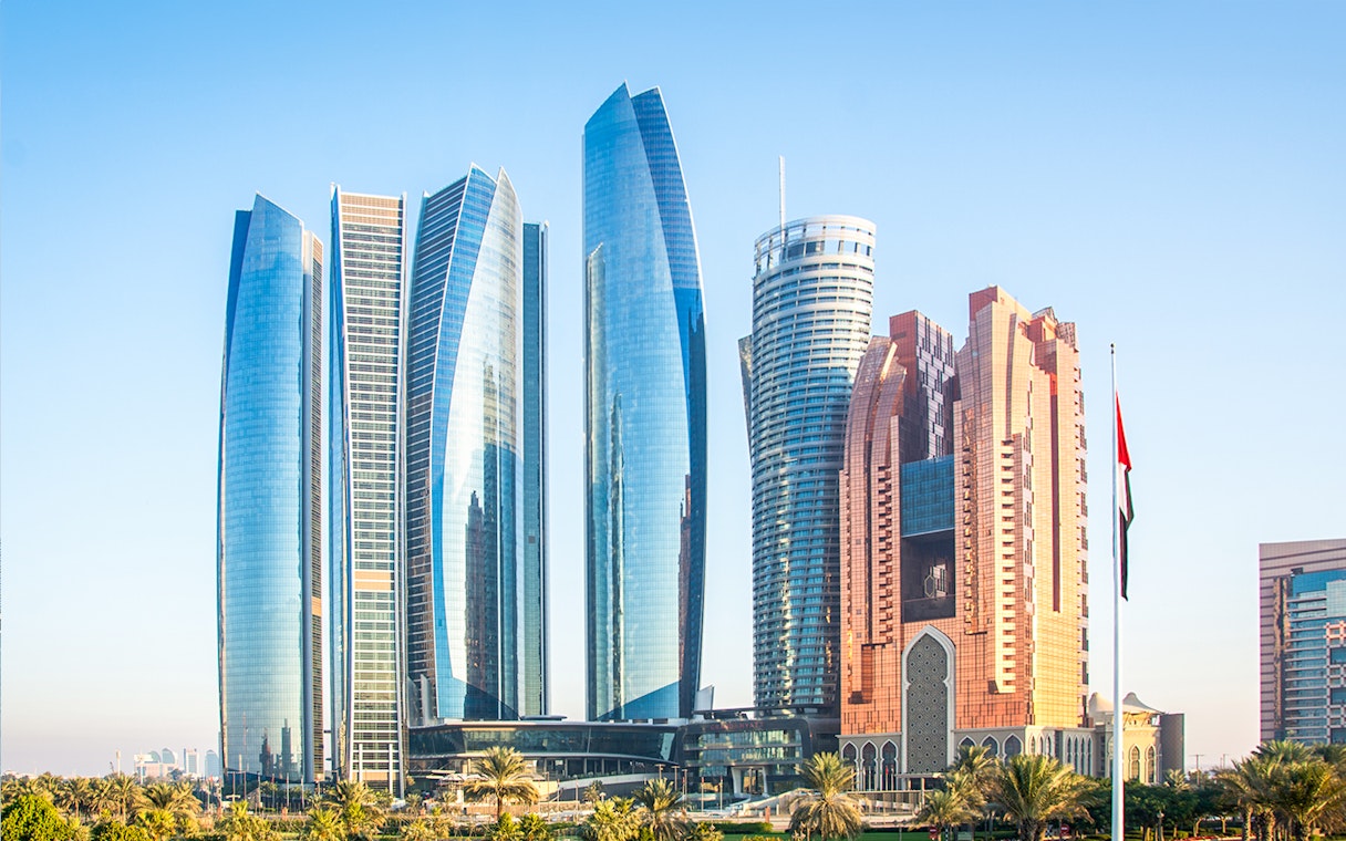 Etihad Towers skyline in Abu Dhabi with modern architecture and palm trees.