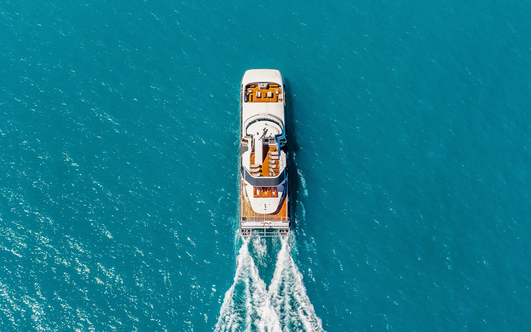 Aerial view of a boat cruising through clear blue waters on the ZigZag Whitsundays Day Tour.