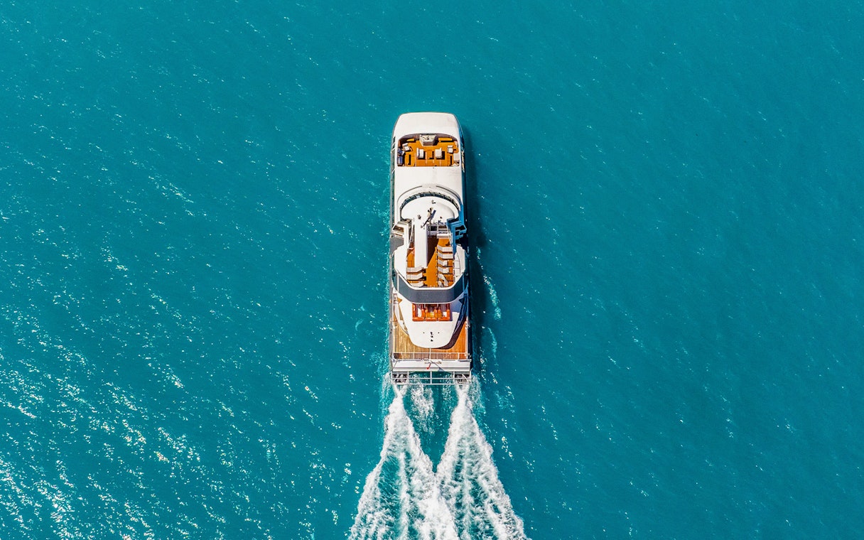 Aerial view of a boat cruising through clear blue waters on the ZigZag Whitsundays Day Tour.