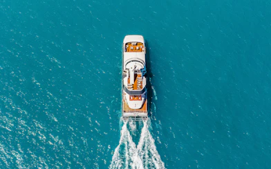 Aerial view of a boat cruising through clear blue waters on the ZigZag Whitsundays Day Tour.
