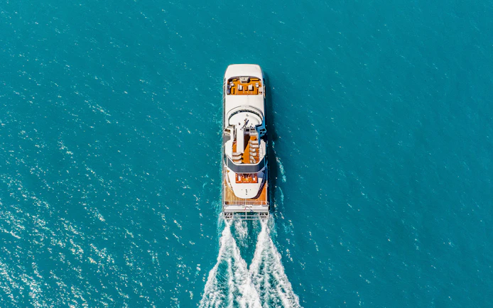 Aerial view of a boat cruising through clear blue waters on the ZigZag Whitsundays Day Tour.