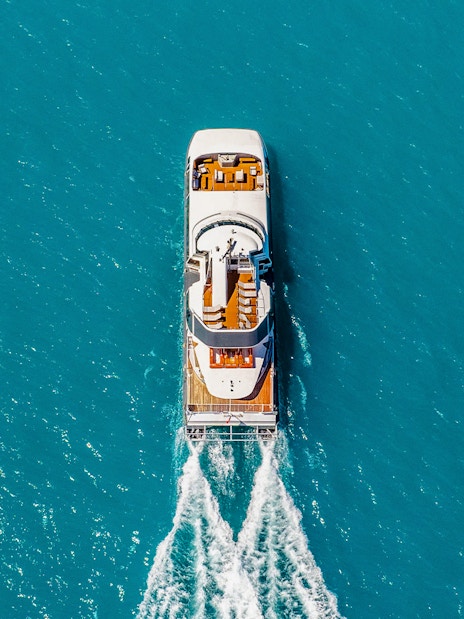 Aerial view of a boat cruising through clear blue waters on the ZigZag Whitsundays Day Tour.