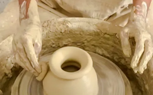 Potter shaping clay on a wheel at an ancestral pottery workshop near Essaouira.