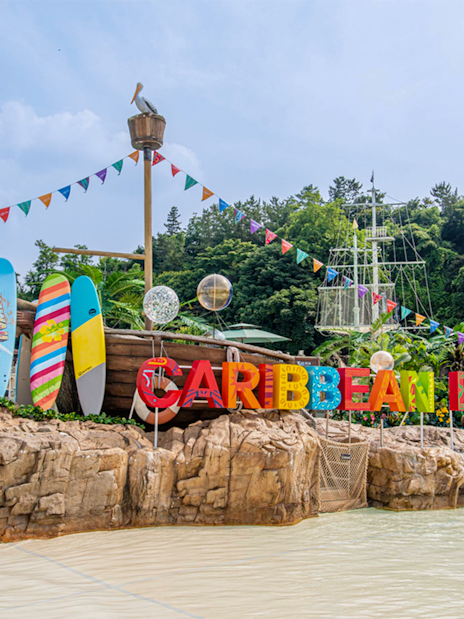 Caribbean Bay Water Park entrance with colorful surfboards and pirate ship theme.