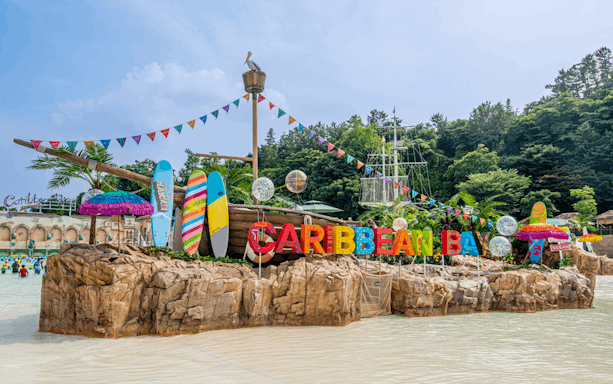 Caribbean Bay Water Park entrance with colorful surfboards and pirate ship theme.