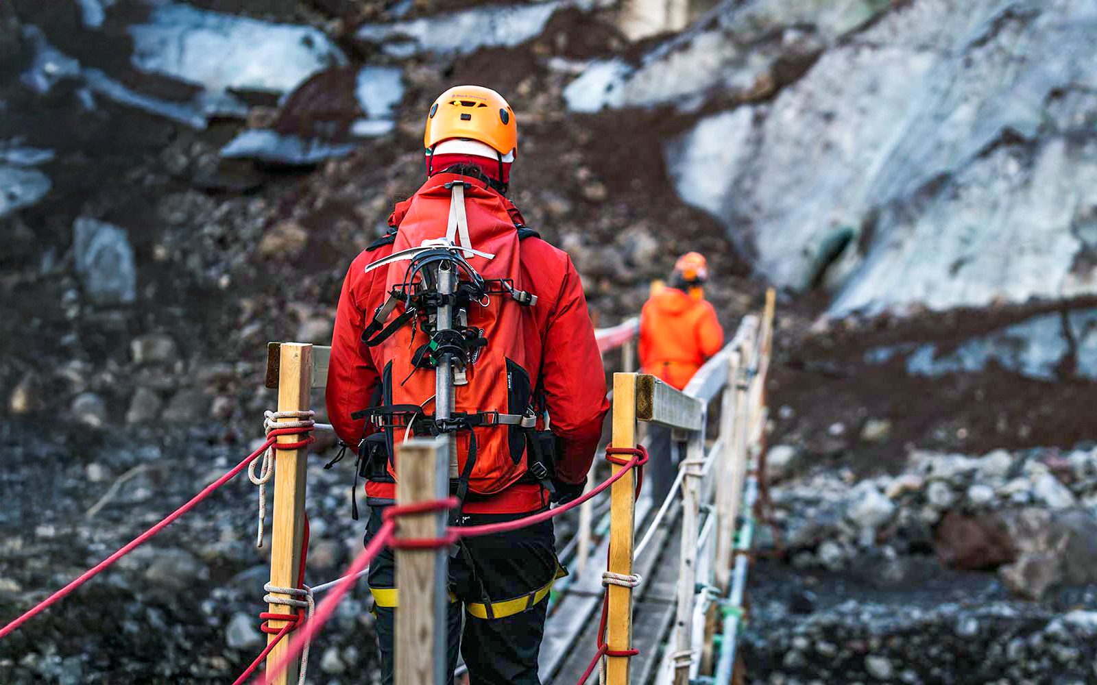 Hikers crossing a bridge on Vatnajökull glacier in Iceland.