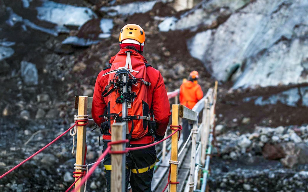Hikers crossing a bridge on Vatnajökull glacier in Iceland.