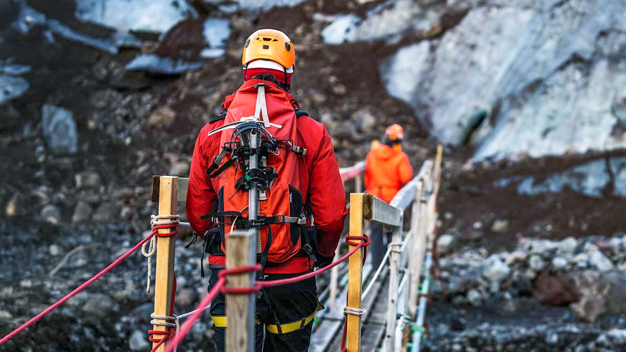 Hikers crossing a bridge on Vatnajökull glacier in Iceland.