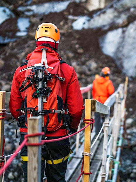 Hikers crossing a bridge on Vatnajökull glacier in Iceland.