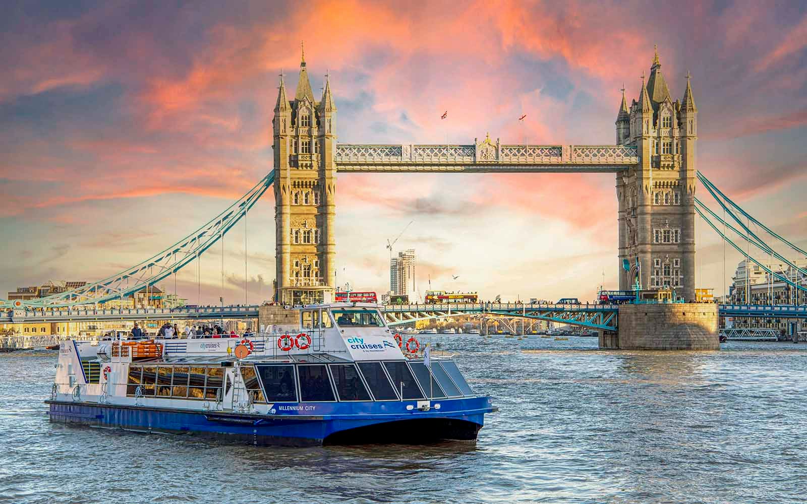 River Thames dinner cruise boat near Tower Bridge with festive Christmas lights in London.