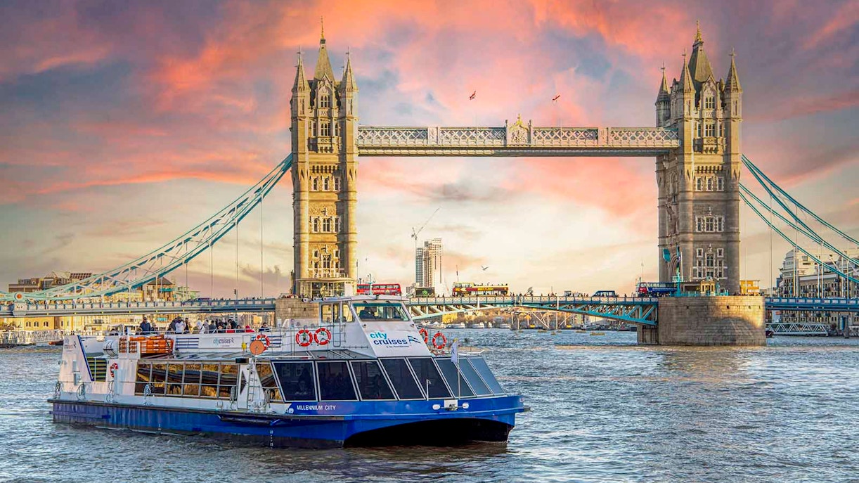 River Thames dinner cruise boat near Tower Bridge with festive Christmas lights in London.