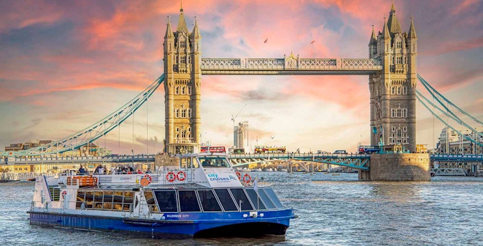 River Thames dinner cruise boat near Tower Bridge with festive Christmas lights in London.