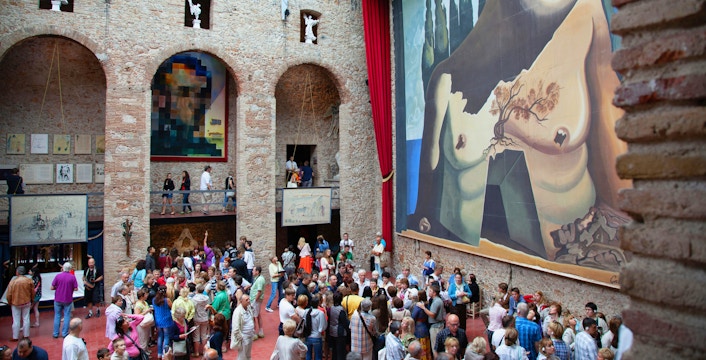 Dalí Theatre and Museum interior with large surrealist mural and visitors in Figueres, Spain.