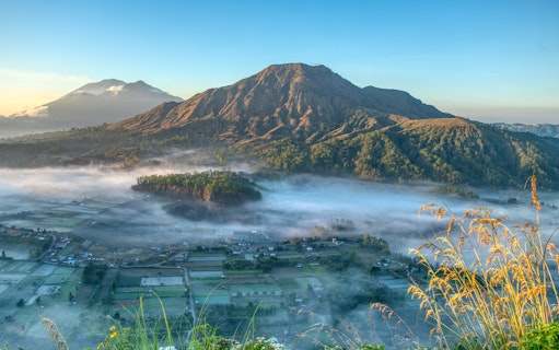 Mount Batur with morning mist and surrounding landscape in Bali, Indonesia.