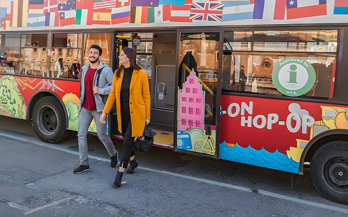 Couple exiting hop-on hop-off tour bus in Copenhagen.