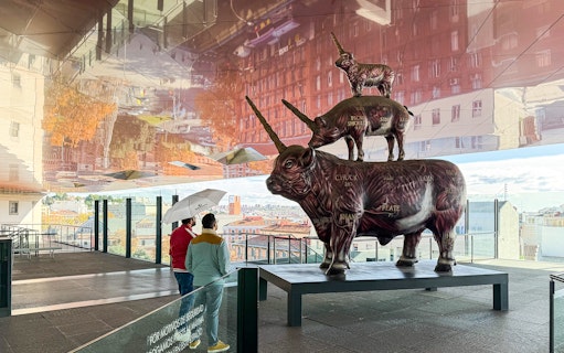 Visitors viewing a stacked animal sculpture at Reina Sofia Museum, Madrid.
