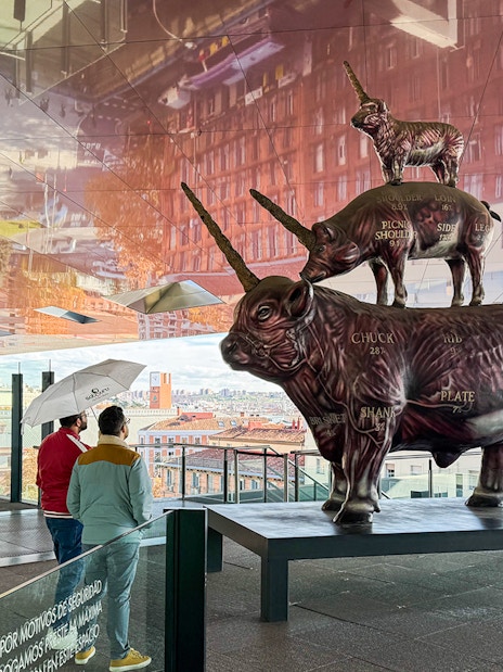 Visitors viewing a stacked animal sculpture at Reina Sofia Museum, Madrid.