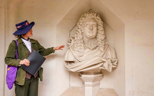 Tour guide explaining a historical statue in London during the Heart of 'The City' Food Tour.