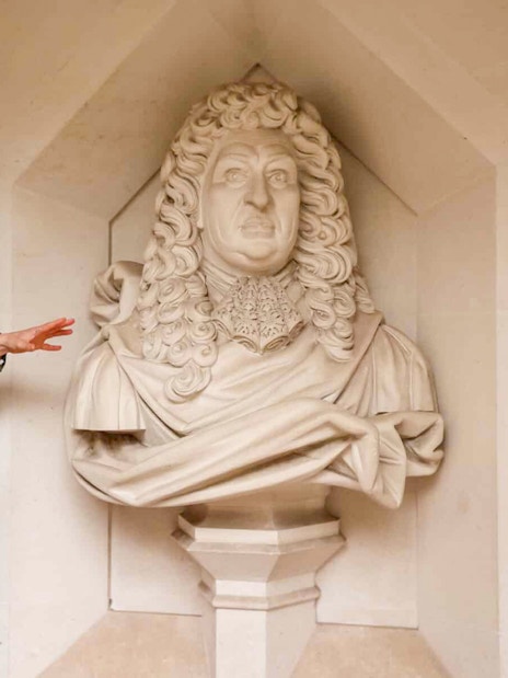 Tour guide explaining a historical statue in London during the Heart of 'The City' Food Tour.