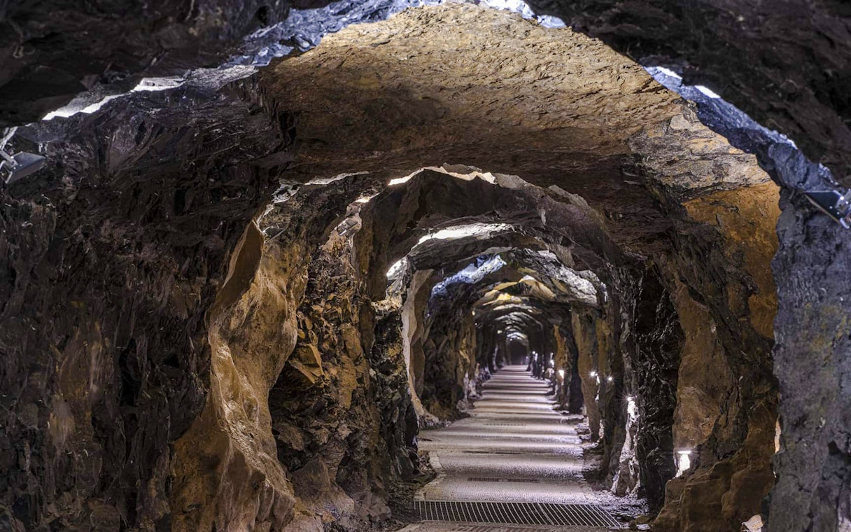 Aillwee Cave tunnel with illuminated rock walls in County Clare, Ireland.