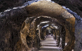 Aillwee Cave tunnel with illuminated rock walls in County Clare, Ireland.