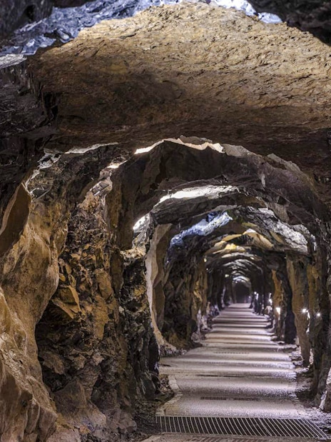 Aillwee Cave tunnel with illuminated rock walls in County Clare, Ireland.