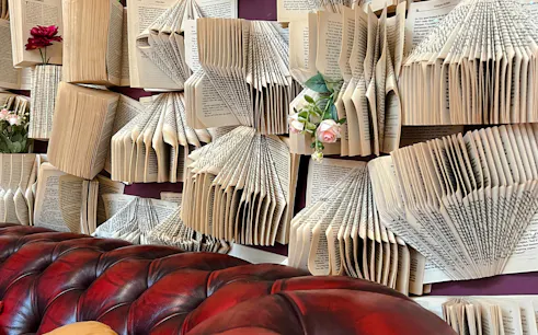 Books arranged creatively on a wall with flowers at Melbourne's Bookstore & Cafe.
