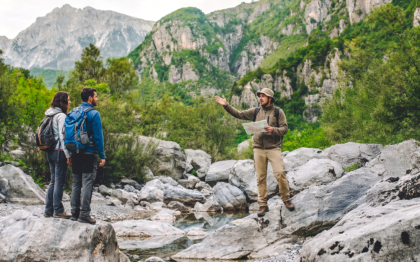 Tour guide explaining to tourists by Komani Lake during Shala River day trip from Tirana.
