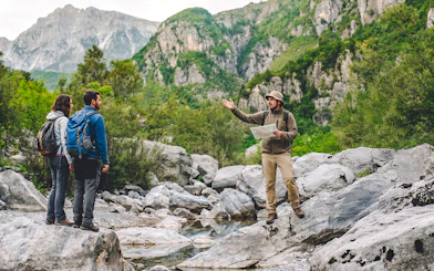 Tour guide explaining to tourists by Komani Lake during Shala River day trip from Tirana.