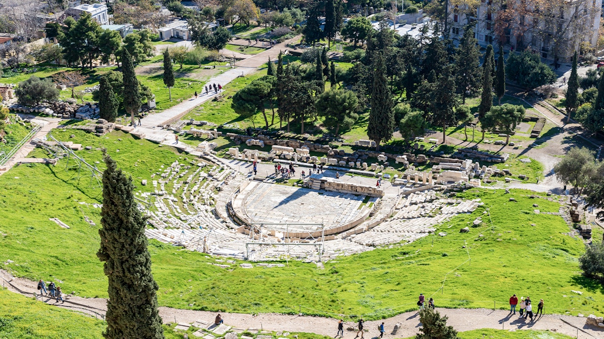 Theater of Dionysus ruins in Athens, Greece, showcasing ancient stone seating and stage area.