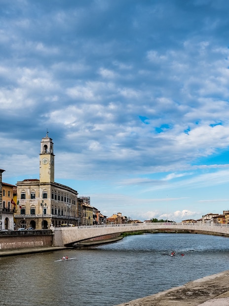 Pisa cityscape with Arno River and historic buildings, viewed during a guided tour from Florence.