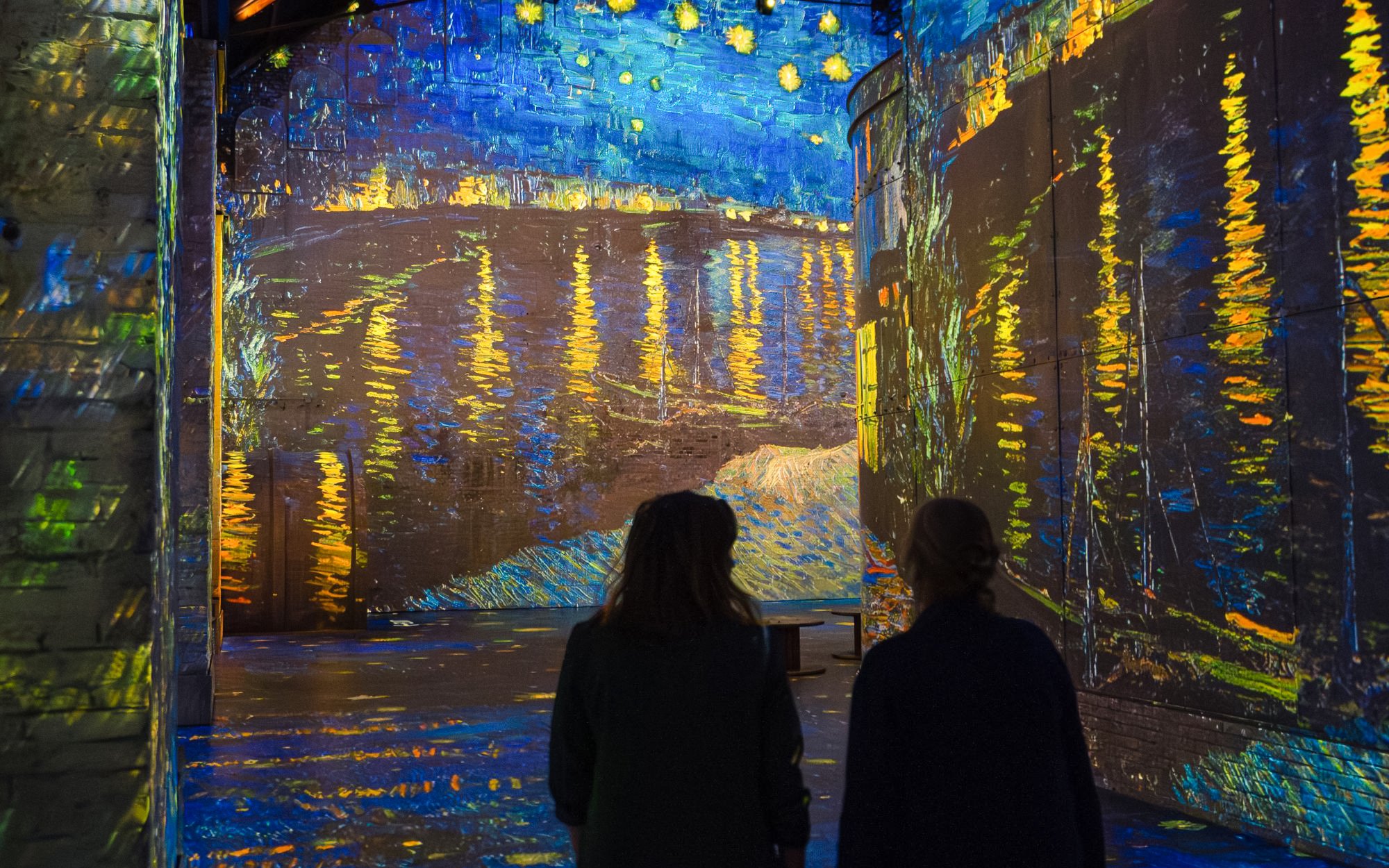 Visitors viewing Van Gogh's "Starry Night Over the Rhône" at Dutch Masters Exhibition, Fabrique des Lumières.