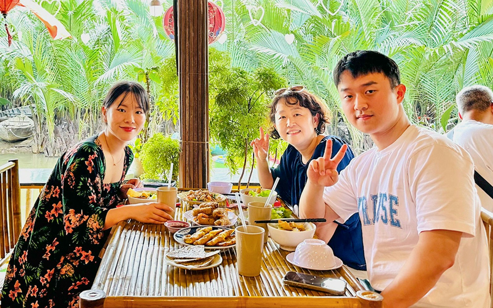 Group enjoying lunch at a riverside restaurant in Hoi An, Vietnam.