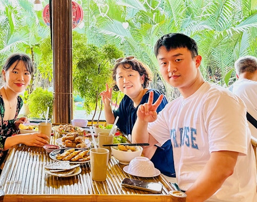 Group enjoying lunch at a riverside restaurant in Hoi An, Vietnam.