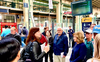 Group of tourists at a Paris train station, preparing for a day trip with lunch on the Eiffel Tower.