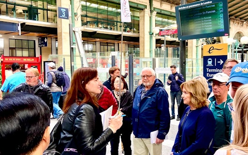 Group of tourists at a Paris train station, preparing for a day trip with lunch on the Eiffel Tower.