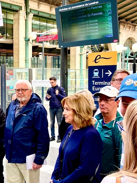 Group of tourists at a Paris train station, preparing for a day trip with lunch on the Eiffel Tower.