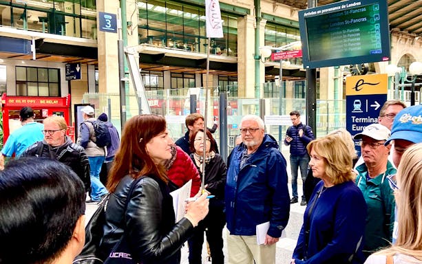 Group of tourists at a Paris train station, preparing for a day trip with lunch on the Eiffel Tower.