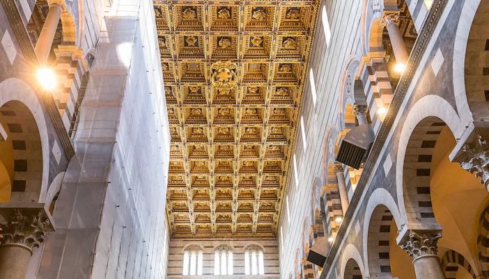 Pisa Cathedral interior with detailed roof murals and view of the Leaning Tower.