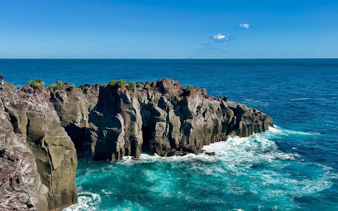 Rugged volcanic cliffs at Jogasaki Coast, Izu Peninsula, Japan, with ocean waves below.