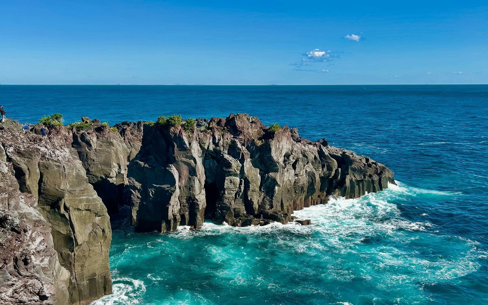 Rugged volcanic cliffs at Jogasaki Coast, Izu Peninsula, Japan, with ocean waves below.