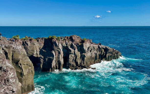 Rugged volcanic cliffs at Jogasaki Coast, Izu Peninsula, Japan, with ocean waves below.