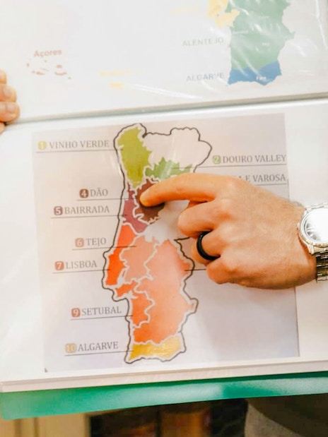 Tour guide pointing at wine regions map during Lisbon food tour.