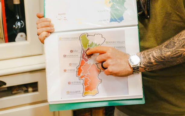 Tour guide pointing at wine regions map during Lisbon food tour.