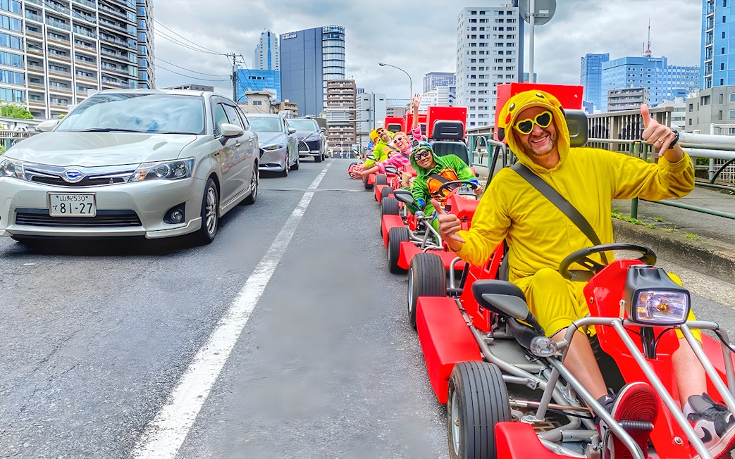 Participants in costumes enjoying street go-karting at Tokyo Bay.